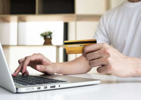 Closeup hand of a men is holding the credit card and using computer - Infintech Designs