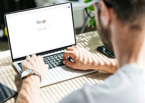 Cropped view of man using laptop with google website on screen - Infintech Designs